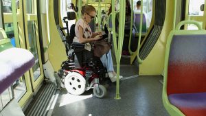 Jeune femme atteinte d'arthrogrypose, se déplaçant en fauteuil roulant dans le tramway de Grenoble