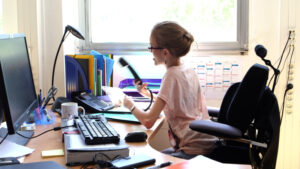 Jeune femme atteinte d'arthrogrypose, au travail dans un bureau